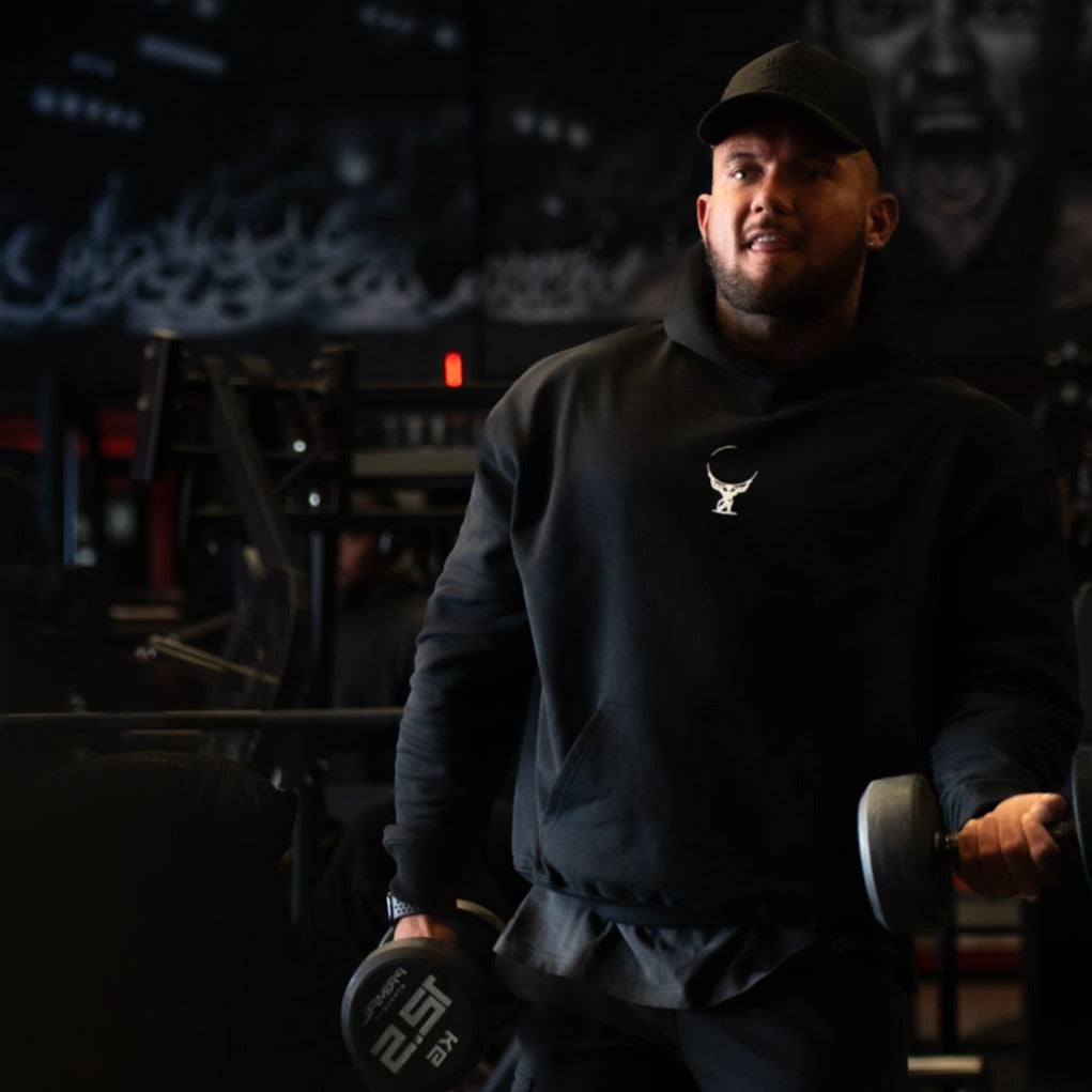 Male athlete wearing the heavyweight black and white Atlas Apparel gym hoodie.