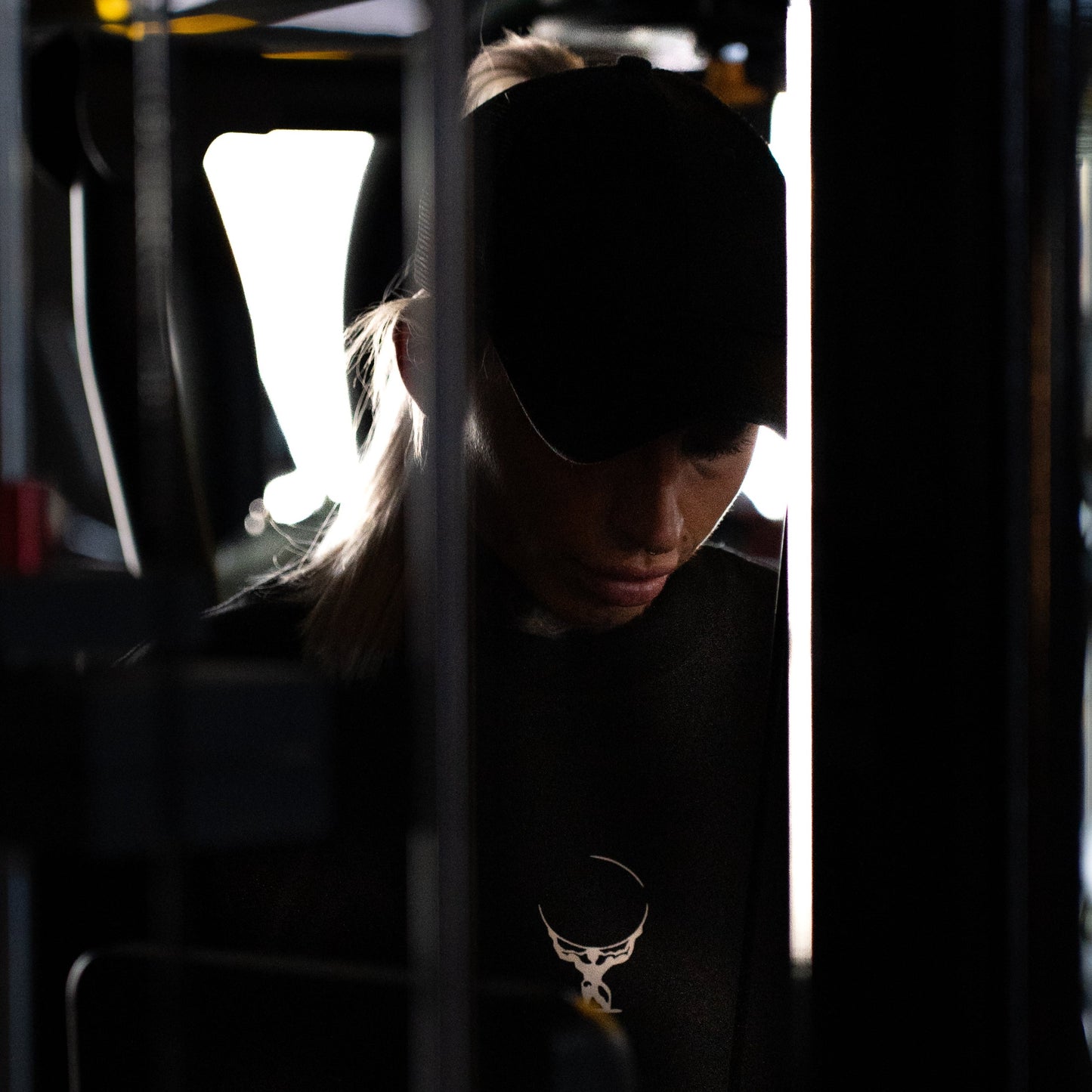 Female athlete wearing the heavyweight black and white Atlas Apparel gym hoodie.