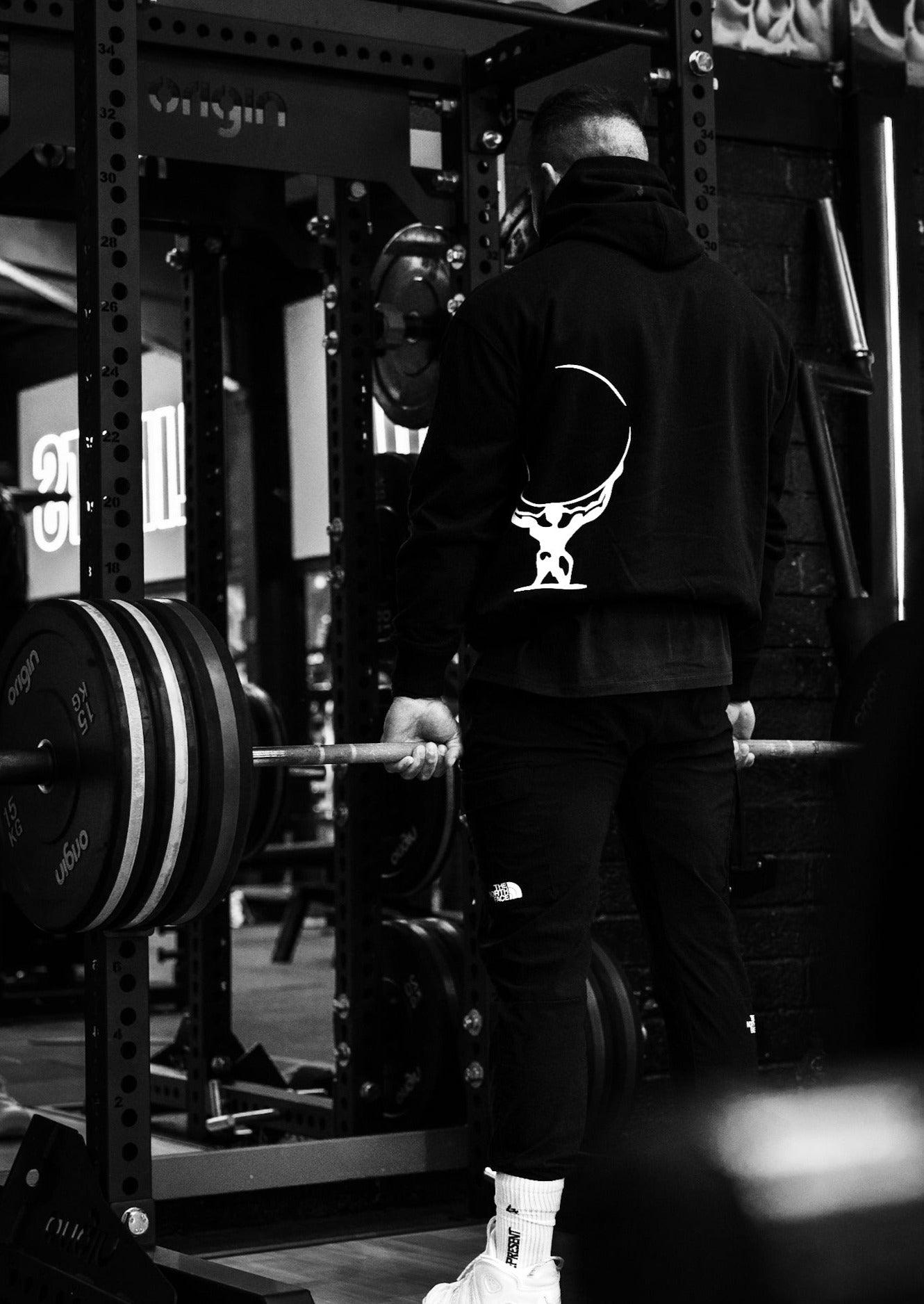 Male athlete wearing the heavyweight black and white Atlas Apparel gym hoodie.